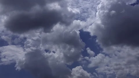 Time-lapse of towering white cumulus clouds drifting across a deep blue sky Stock Footage 341679965