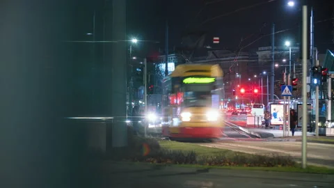 Time-lapse traffic jam busy crossroad, yellow trams moving fast in evening city Video stock 166442719