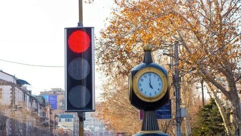 Time lapse: traffic lights with a clock on the city background Stock Footage 75340015