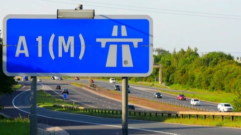 Time lapse traffic passing A1(M)  motorway sign leeds yorkshire united kingdom Stock Footage 114740395