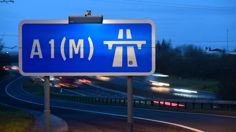 Time lapse traffic passing A1(M) motorway sign at twilight uk Stock Footage 125852881