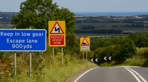 Time lapse traffic passing escape lane sign on steep hill uk Stock Footage 53020545