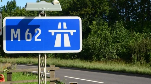 Time lapse traffic passing m62 motorway sign leeds yorkshire uk Stock Footage 113856837