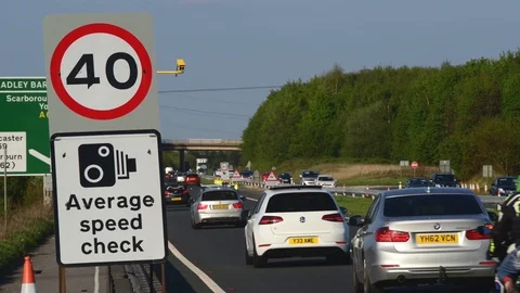 Time lapse traffic passing warning sign of average speed cameras uk Stock Footage 90279096