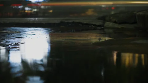 Time-lapse of traffic reflections in a rainy street puddle Stock Footage 345980839