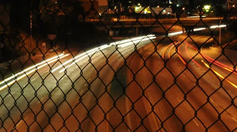 Time Lapse of Traffic through Chain Link Fence - 4K Stock Footage 25636122