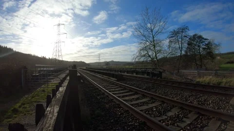 Time lapse train on rail track with High Voltage Tower and blue skies Stock Footage 170883982