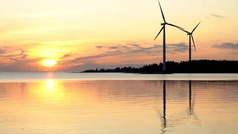 Time-lapse of two wind turbines, silhouettes at sunset on the Baltic sea Video stock 117350982