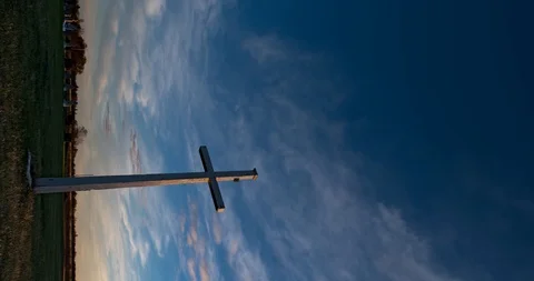 Time-lapse of very slow moving red clouds in a blue sky with a large white cross Stock Footage 108496560