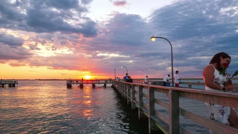 Time lapse of a vibrant sunset over a busy fishing pier Stock Footage 135834636
