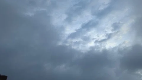 A time-lapse video captures heavy grey clouds moving across the sky. The th.. Video stock 329140731
