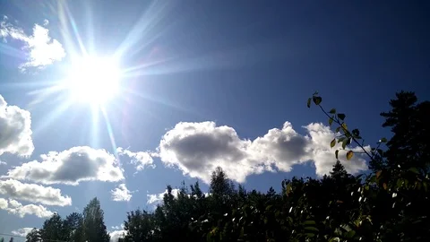 A Time Lapse video of clouds and sun above forest trees Stock Footage