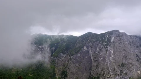 Time lapse video of dramatic scenery with clouds twirling above Alpine mountains Stock Footage 77197582