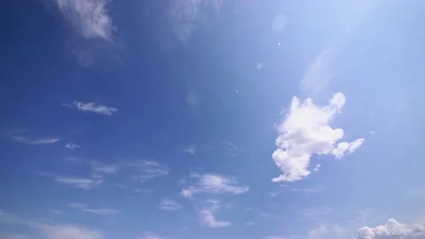 Time lapse video of light white clouds moving fast in the sky on a clear summer Stock Footage 148619362