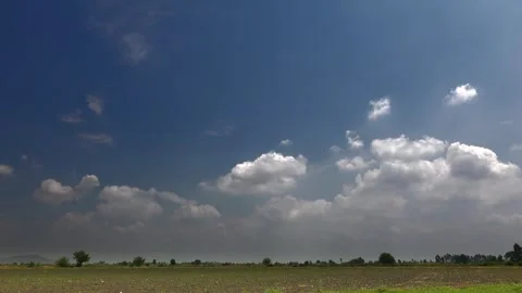 Time lapse video of partly cloudy blue sky over flat plain farmland - Revealing Stock Footage 339488733