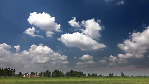 Time lapse video of partly cloudy blue sky over flat plain farmland - Moody Sky Stock Footage 339488904