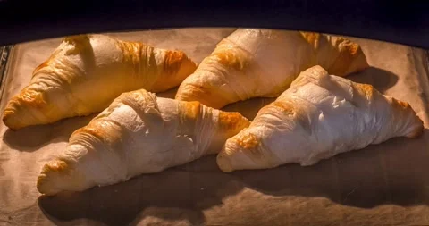Time lapse video of the process of baking a group of croissants in the oven. Video stock 154928058