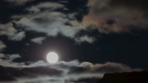 Time-lapse video of rising full moon behind fast moving clouds Stock Footage 149684936