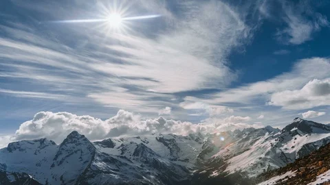 Time lapse video of snow-capped mountains with clouds and sun Stock Footage 127944027