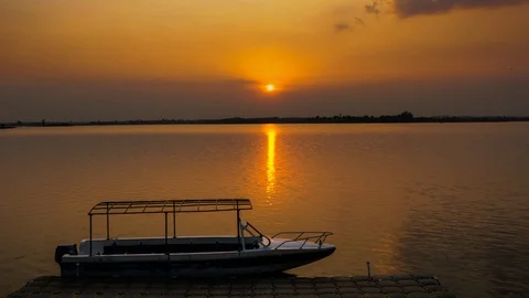Time lapse video of sunset at lake, boat moving at the shore Stock Footage 113480040