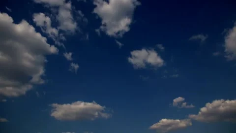 Time-lapse video of a variety of fluffy white clouds floating in a blue sky Stock Footage 341458917