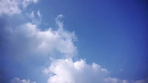 Time-lapse video of white clouds moving fast across a bright blue sky, Stock Footage 336206401