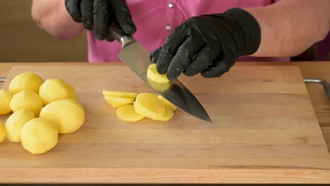 Time lapse video of a womans hands in black gloves are cutting potatoes to pre Stock Footage 129176395