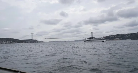 Time Lapse- View of the bosphorus bridge on a cloudy day  with ferry passing Stock Footage 98533322