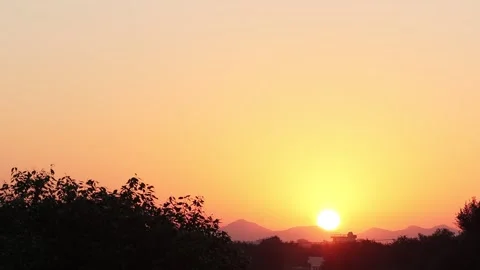 Time lapse View of the bright sun rise in the morning. The sun shines from be Stock Footage 149874657