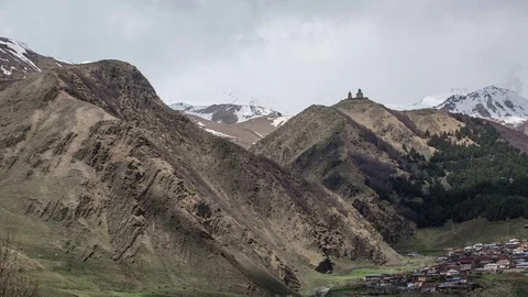 Time-lapse with a view on Kazbegi mountains and anchient Gergeti church Stock Footage 76261740