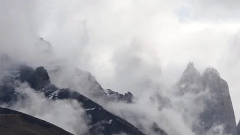 Time lapse view on moving white clouds hiding and showing the top of mountains Video stock 264758696