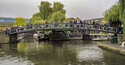 Time lapse view of people crossing a bridge over the canal at Camden town Stock Footage 69242619