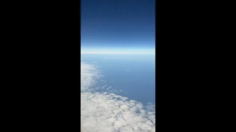 Time-lapse view of the sky with white clouds from an airplane window at high alt Stock Footage 310441594