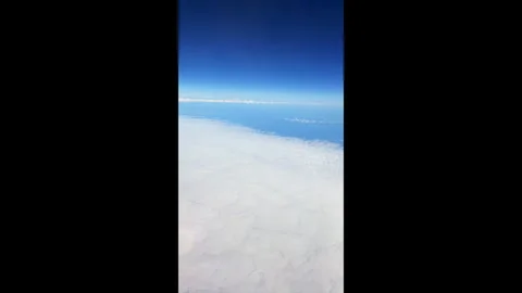 Time-lapse view of the sky with white clouds from an airplane window at high alt Video stock 310441627