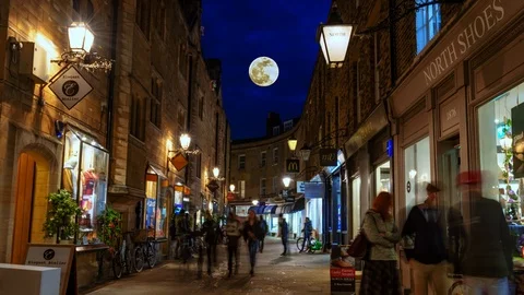 Time lapse view of a small busy lane in Cambridge at night with full moon rising Stock Footage 109561762
