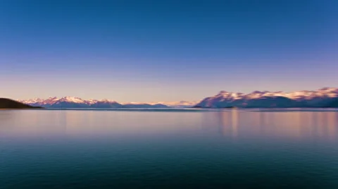 Time lapse view of snow capped mountains along the glassy water in Alaska. Stock Footage 52218293