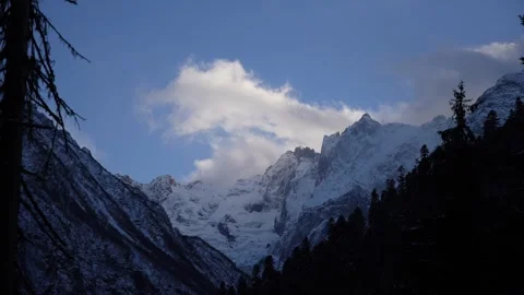 Time-lapse view of snow-capped mountain peaks with clouds Stock Footage 310230517