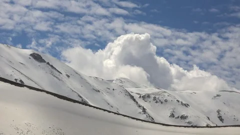 Time lapse view of a treeless snowy mountain ridge under dynamic shifting clouds Stock Footage 339350484