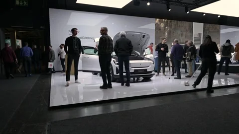 Time lapse of visitors at a car show looking at a Polestar 2 electric car Stock Footage 334962399
