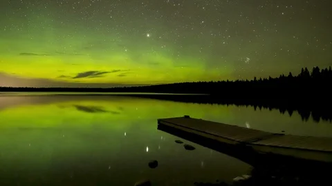 Time lapse of vivid Aurora and stars reflecting calm lake Stock Footage 118384404