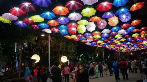 Time lapse of walking visitors under colourful umbrellas Stock Footage 41423648