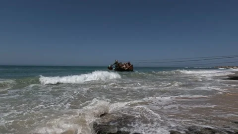 Time-lapse of waves on the beach with the abandoned fishing boat. 스톡 동영상 238477993