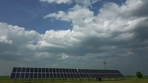 Time lapse of white and gray clouds moving above an array of solar panels  Stock Footage 244135542