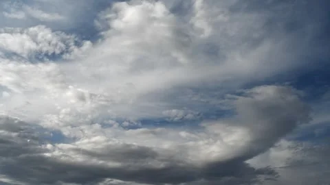 Time lapse of white and gray clouds moving across a dark blue sky. Stock Footage 296657195