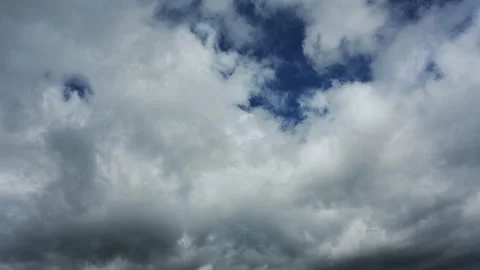Time lapse of white and gray clouds moving through a dark blue sky Stock Footage 297401028