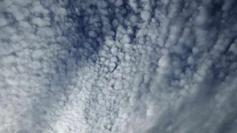 Time lapse of white and gray summer clouds moving across a dark blue sky. The Stock Footage 335215088
