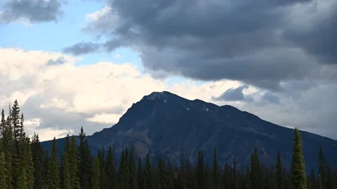 Time lapse of white and grey clouds moving across a distant mountain Stock Footage 139285289
