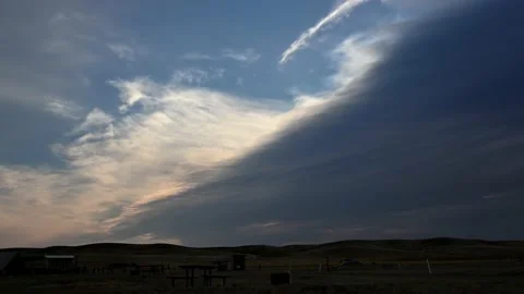 Time lapse of white and grey clouds moving towards the viewer above a campground Stock Footage 219488746