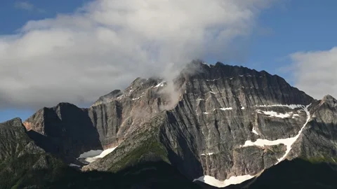 Time lapse of white and grey clouds moving towards the viewer over a mountain Stock Footage 233115779