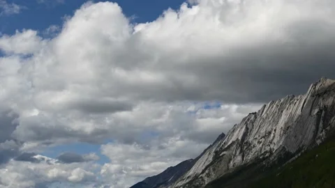 Time lapse of white billowing clouds in a blue sky with mountains. Stock Footage 152526121
